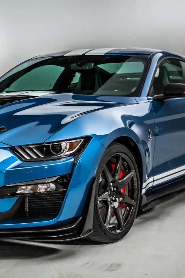 Metallic blue Ford Mustang Shelby GT500 with red brake calipers and black wheels.