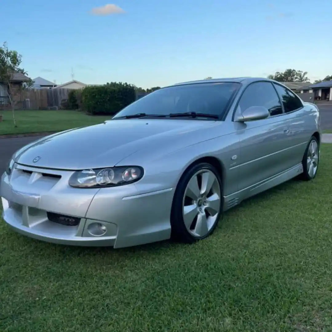 Silver Holden Monaro coupe with aftermarket body modifications.